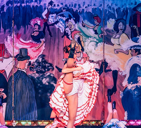 Cabaret performers on stage at Nouvelle Eve in Paris, featuring vibrant costumes and dynamic choreography.
